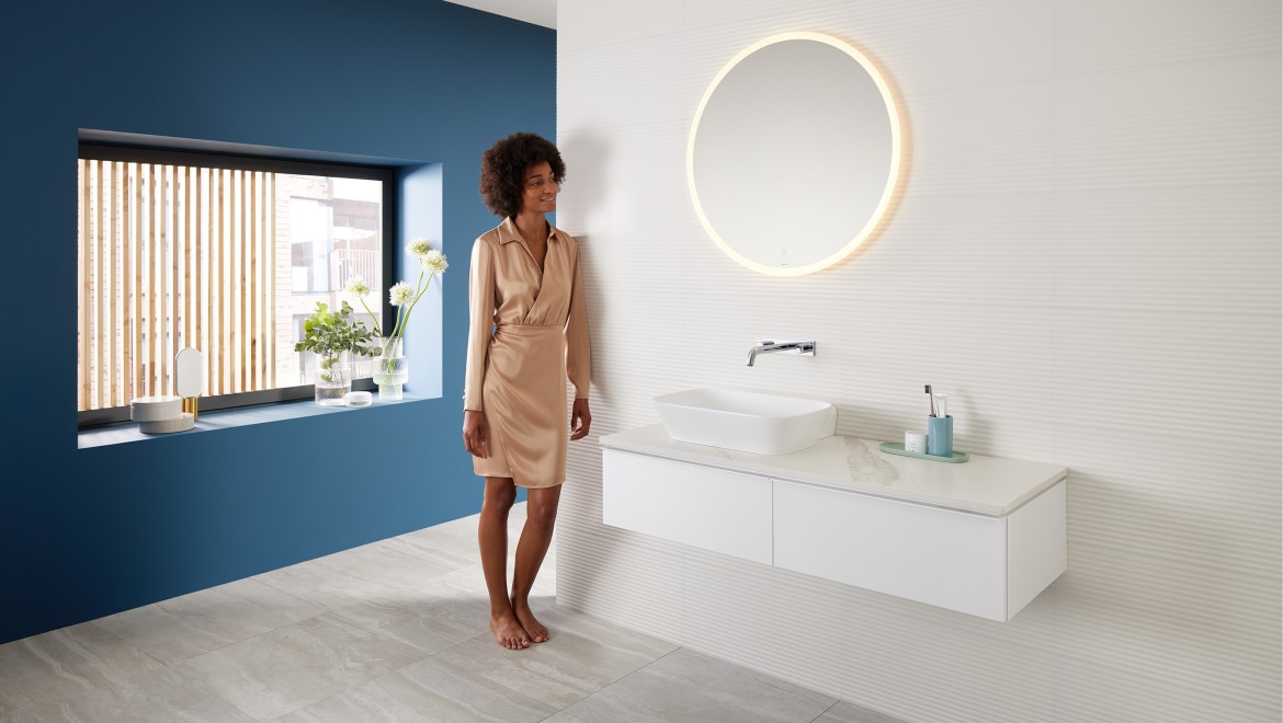 Vrouw staat in de badkamer die is samengesteld met producten uit het Mix & Match-assortiment van Geberit Vrouw staat in de badkamer die is samengesteld met producten uit het Mix & Match-assortiment van Geberit