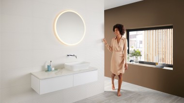 Vrouw in de badkamer in de trendy bruintint met een Mix & Match wastafelcombinatie.
