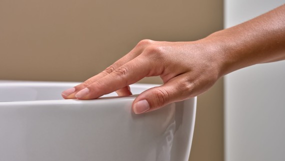 Hand streelt over wc met speciale KeraTect® glazuur Hand streelt over wc met speciale KeraTect® glazuur
