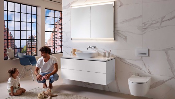 Man en kind in een modern wit ingerichte Geberit ONE-badkamer
