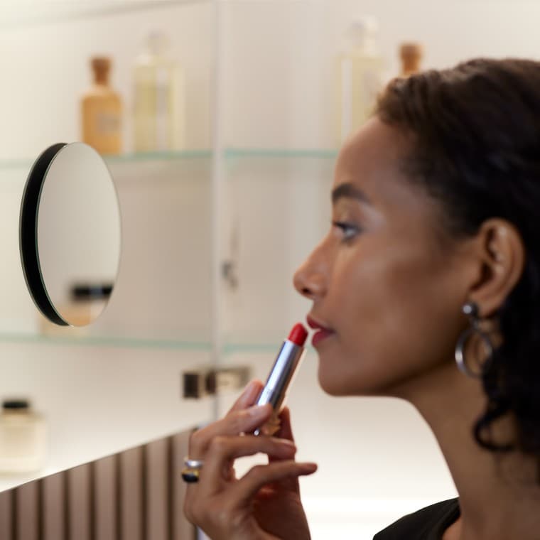 Vrouw die make-up aanbrengt voor de spiegel Vrouw die make-up aanbrengt voor de spiegel