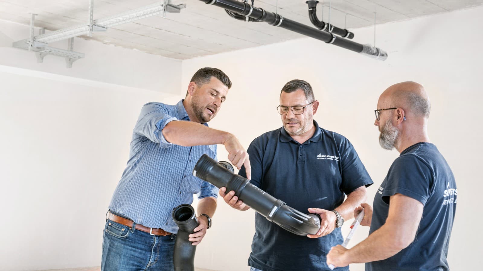 Geberit accountmanager Fabian Ritter licht de nieuwe Geberit Silent-Pro BottomTurn bocht toe aan projectmanager Marcel Roth en zijn team. Geberit accountmanager Fabian Ritter licht de nieuwe Geberit Silent-Pro BottomTurn bocht toe aan projectmanager Marcel Roth en zijn team.